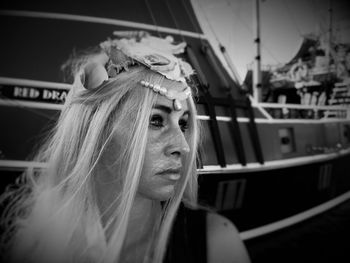 Close-up of young woman wearing headdress against ship