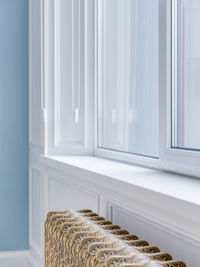 Gold retro heater under a large window in a bright spacious room close-up