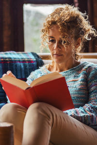 Young woman sitting on sofa at home