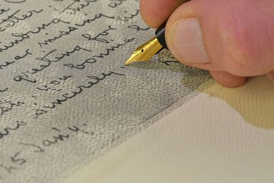 Close-up of a male hand ready to write with an elegant fountain pen. handwriting.