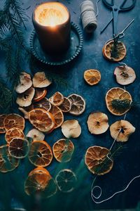High angel view of slices of dried fruits on table together with candle light