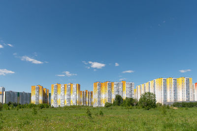 Buildings in city against blue sky