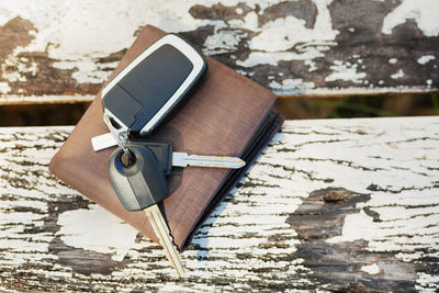 High angle view of keys and wallet on wooden table