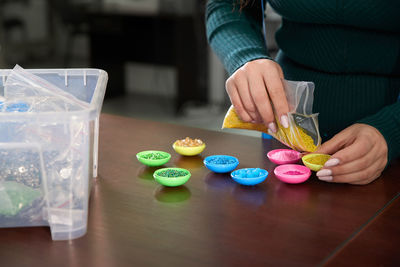 Midsection of woman holding ice cream on table