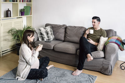 Young couple sitting on sofa at home