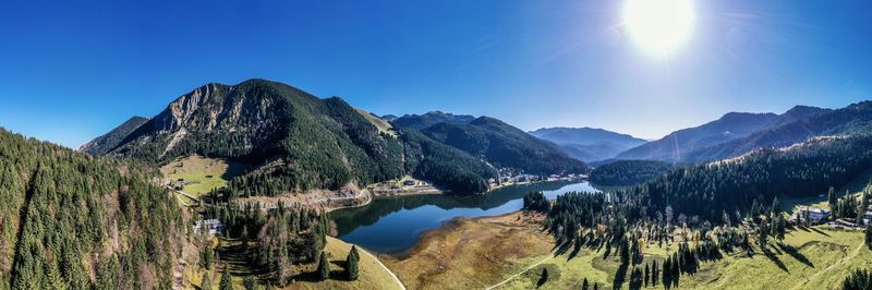 Panoramic view of lake and mountains against clear blue sky