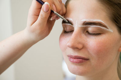 Close-up of woman applying nail