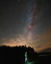 Full length of man standing against star field at night