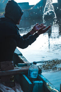 Side view of man holding ice during winter