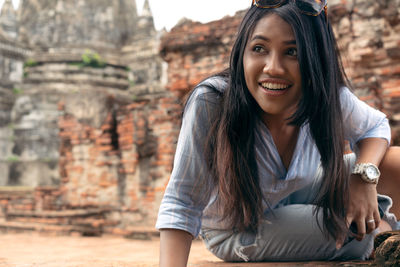 Portrait of smiling young woman sitting outdoors