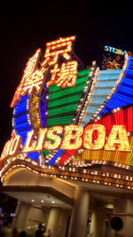 Low angle view of illuminated carousel against sky at night