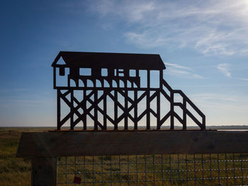 Low angle view of lifeguard hut on field against sky