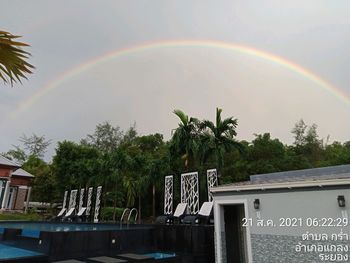 Scenic view of rainbow over plants against sky