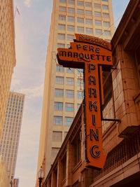 Low angle view of information sign against buildings in city