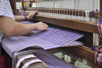 Midsection of woman playing guitar in factory