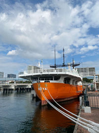 Boats moored at harbor against sky