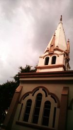 Low angle view of building against cloudy sky