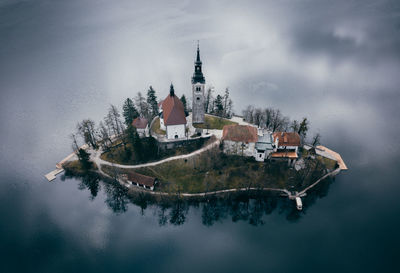 High angle view of houses on island in lake during foggy weather