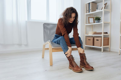 Full length of woman sitting on floor