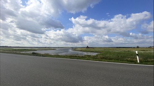 Scenic view of road by land against sky