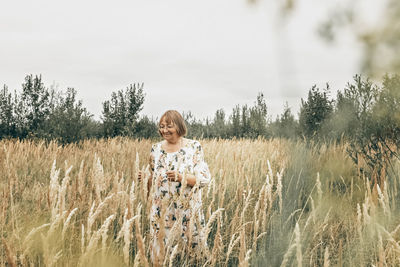 Woman standing on field against sky