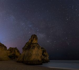 Scenic view of rock formation against sky at night