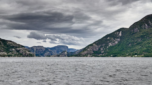 Scenic view of sea and mountains against sky