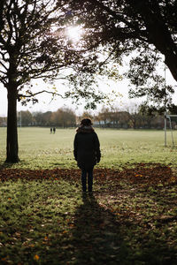 Rear view of man walking on field