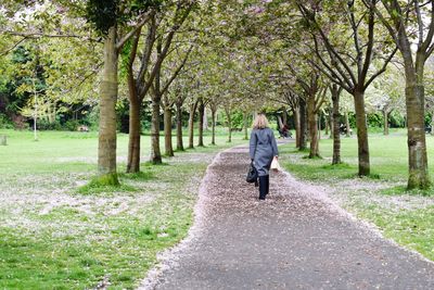 Rear view of woman walking on road