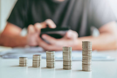 Close-up of hand holding coin stack