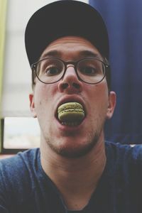 Portrait of young man eating macaroon