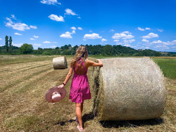 Hay bales on field against sky