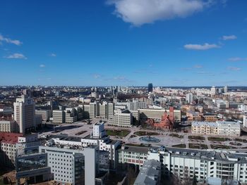 High angle view of buildings in city against blue sky