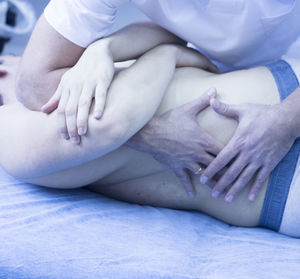 Midsection of doctor massaging patient in hospital