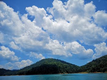 Scenic view of sea and mountains against sky