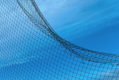 Low angle view of barbed wire against blue sky