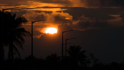 Silhouette palm trees against romantic sky at sunset