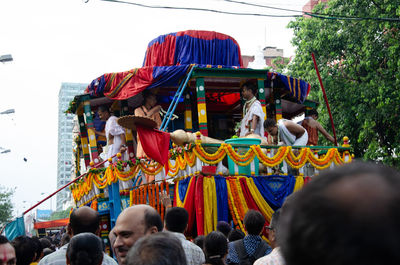 Rear view of people on multi colored umbrellas against sky