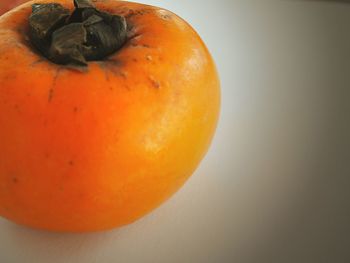 Close-up of orange fruit against white background
