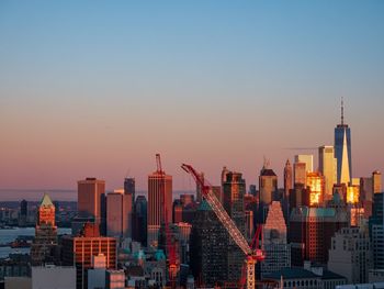 Buildings in cityscape against sky during sunset