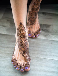 Low section of woman with tattoo on floor
