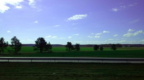 Scenic view of grassy landscape against cloudy sky