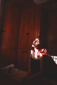 Portrait of young woman sitting on wood