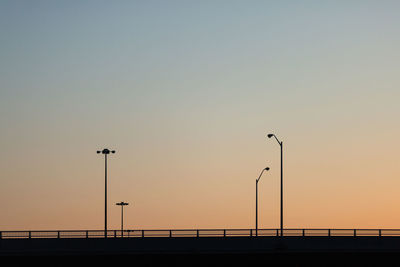 Silhouette bridge against clear sky during sunset