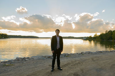 Full length of man standing on beach against sky