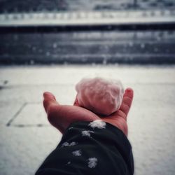 Cropped hand holding cotton ball during winter