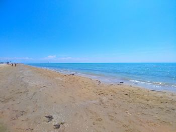 Scenic view of beach against blue sky