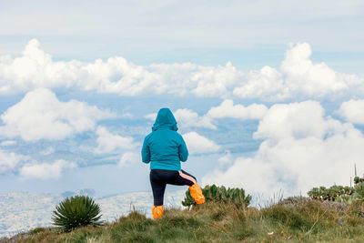 Rear view of man standing on field against sky