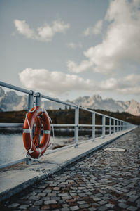 Empty footbridge against cloudy sky