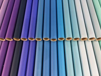 Full frame shot of colorful fabrics rolled around cardboard at store